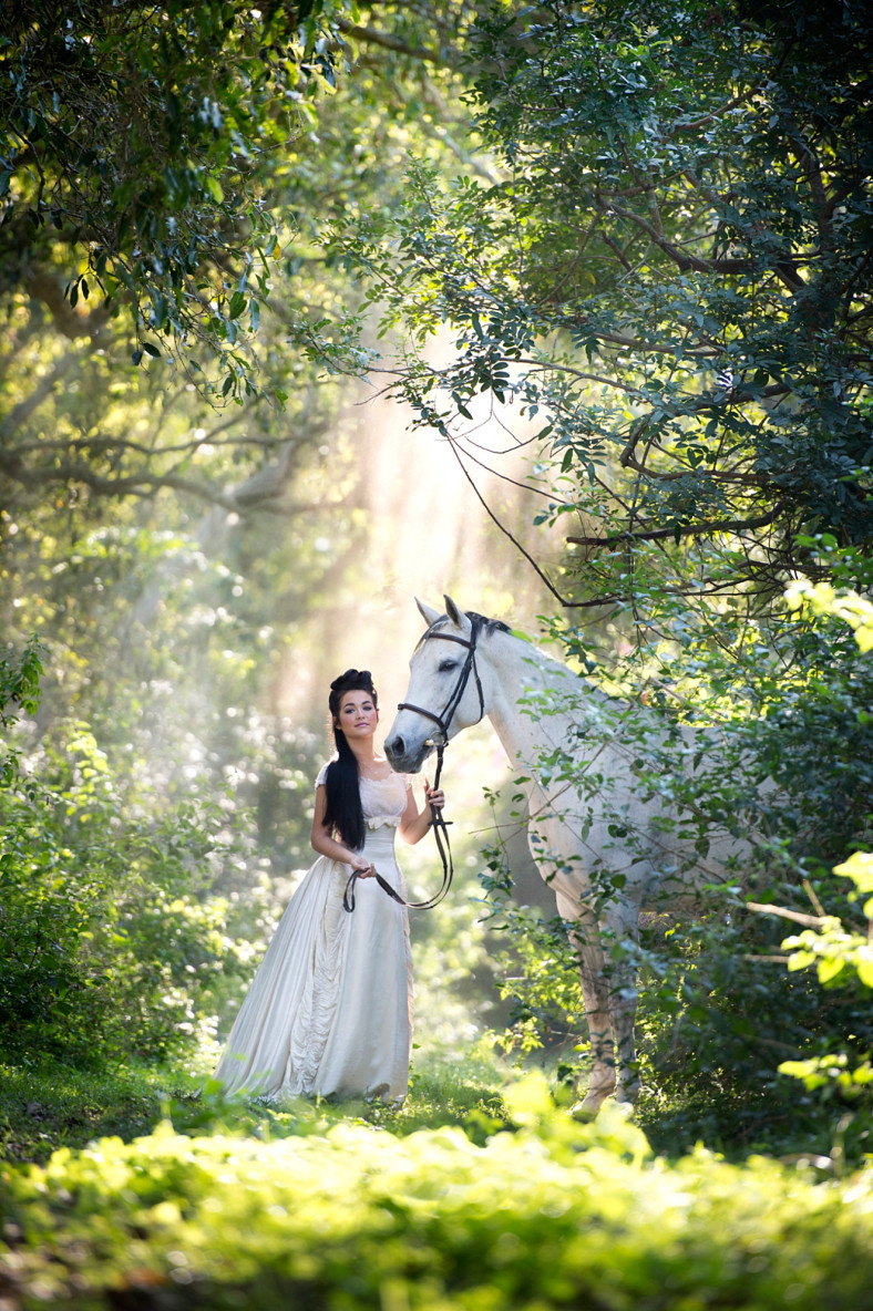 Girl in white dress with horse in amazing light