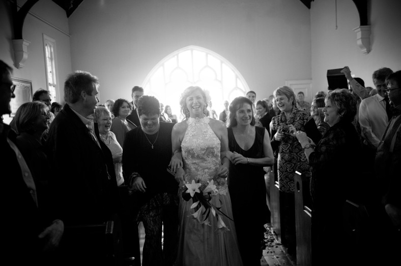 women walk bride down the aisle