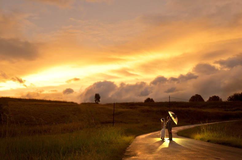 bride and groom on a road at sunset