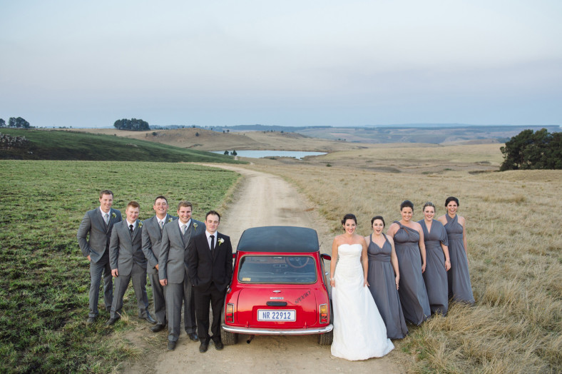 bridal party on a road with a car