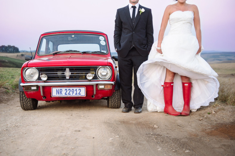 bride in boot with groom by car