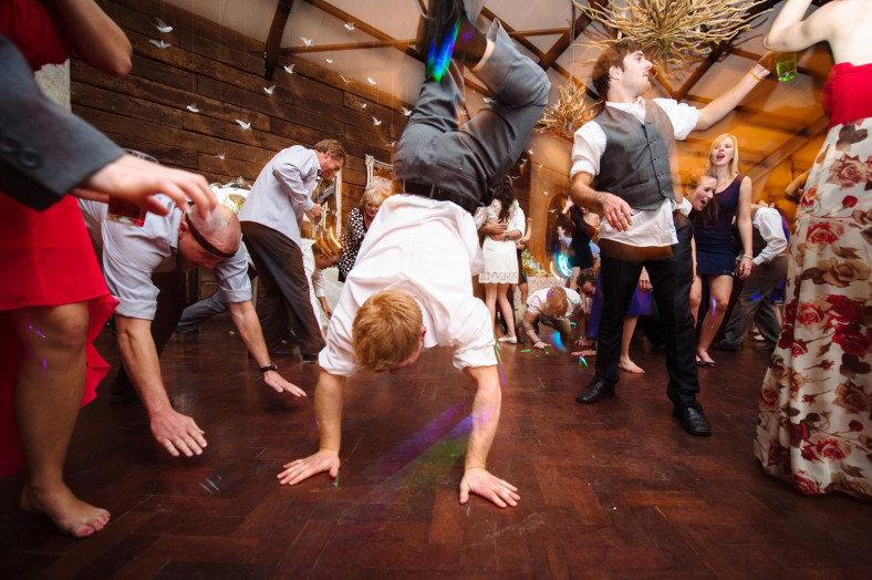 man doing handstand at a wedding