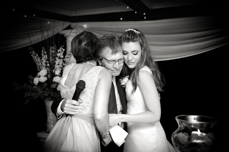 mom and daughter hug father