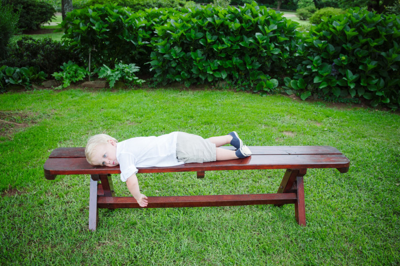 child sleeping on bench