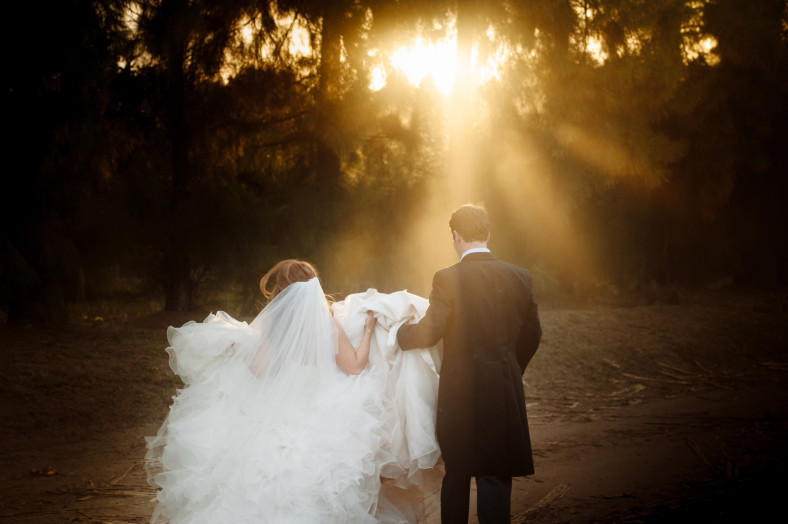 Bride and Groom walking away into light beams