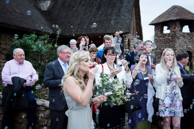 girl blowing bubbles at wedding