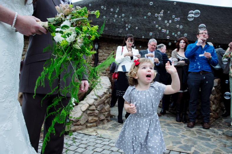 girl blowing bubbles at wedding