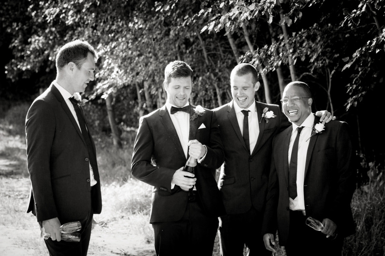 Men popping champagne