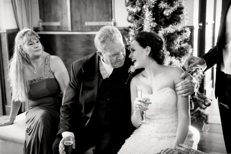 Bride sits on dads lap