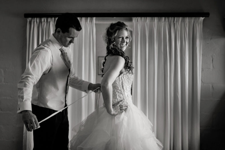 Bride getting into wedding dress