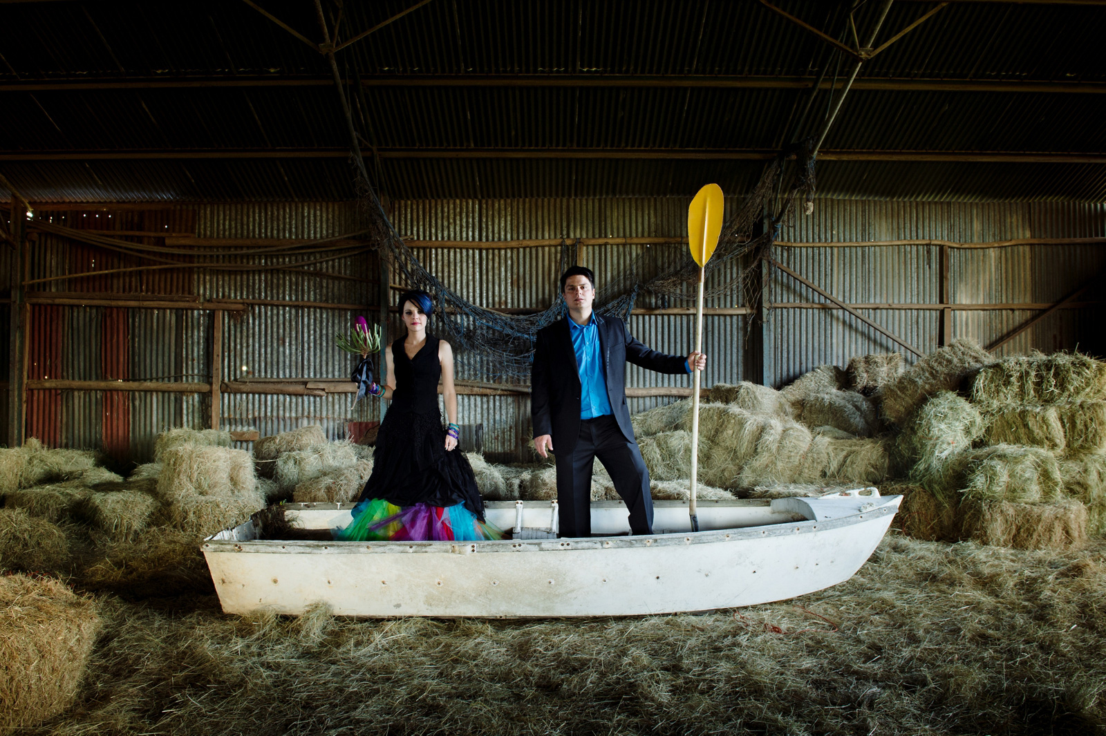 bride and groom in a boat in a barn
